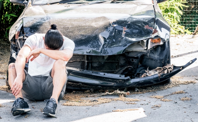 Man crying on his car after crash accident